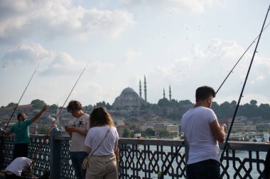 Golden Horn 'daki Galata Köprüsü' nde balık tutan adam.