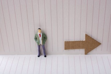 Heykelcik ve tuval üzerine bir defter kağıt ok