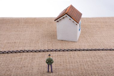 Adam heykelcik ve bir tuval zinciri hatta ötesinde bir Model ev ayakta