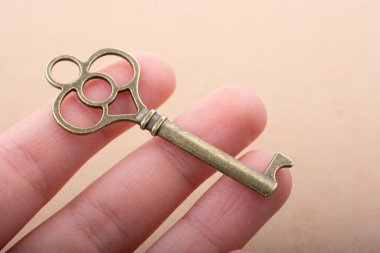 Elinde eski moda dekoratif bir anahtar var.