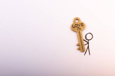 Beyaz arka planda kalp şeklinde anahtar taşıyan bir adam.