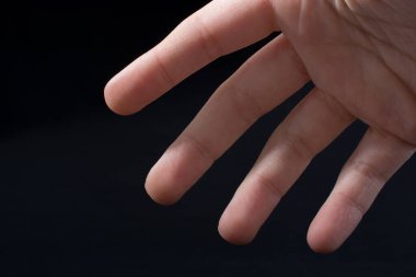 Bir çocuğun dört parmağı kısmen siyah arkaplanda görülüyor