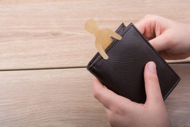 Elinde cüzdanla kağıttan kesilmiş bir adam şekli.