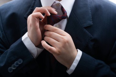 Kravat düğümünü düzelten bir adama yaklaş. Moda ve zarafet konsepti
