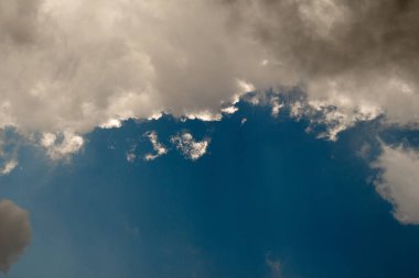 Beyaz renkli bulutlar gündüz vakti mavi gökyüzünü kaplar.