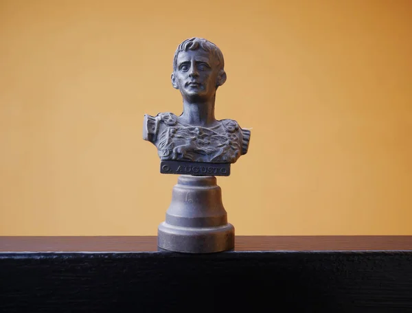 Scale reproduction of the bust of Augustus the first Roman emperor on an orange background