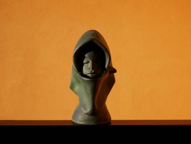 Scale reproduction of the head of a Sardinian woman on an orange background, Sardinia, Italy