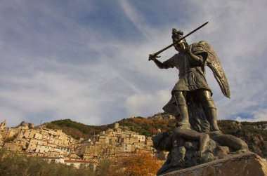 Pesche - Isernia - Molise - Önplanda San Michele heykeli ve ejderha ve arka planda taş evleri olan karakteristik köy.