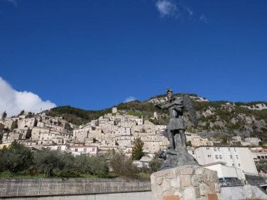 Pesche - Isernia - Molise - Önplanda San Michele heykeli ve ejderha ve arka planda taş evleri olan karakteristik köy.