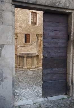  Capestrano 'daki Piccolomini Kalesi' nin girişlerinden biri 15. yüzyıl kuyusunun önündeki iç avluya bakıyor.