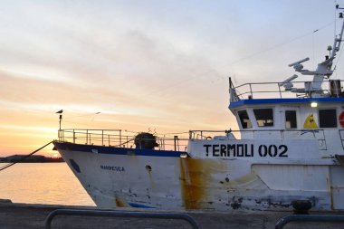 Termoli, Molise limana demirlemiş büyük bir balıkçı teknesi. Termoli limanında gün doğumu - Molise