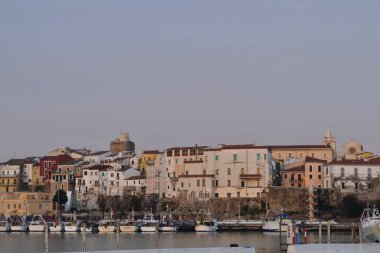 Termoli - Molise - Ön planda bir balıkçı teknesi limana yanaştı ve arka planda antik köy