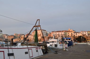 Termoli - Molise - Ön planda bir balıkçı teknesi limana yanaştı ve arka planda antik köy