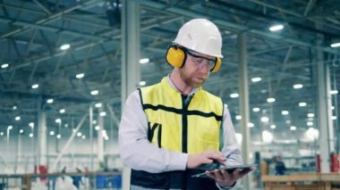 Male specialist is managing working process at the factory. 4K