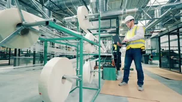 工場労働者は繊維ガラスが巻き込まれるのを観察している — ストック動画