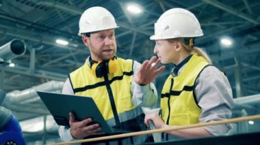 Factory specialists are discussing production process. 4K