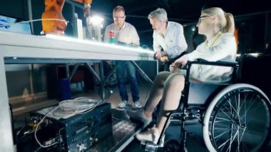 A woman in a wheelchair and her colleagues are researching robots 4K