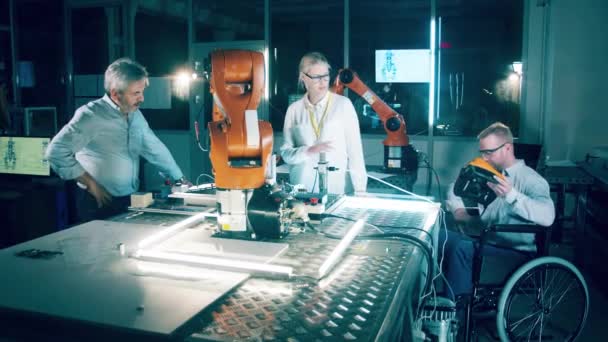 Engenheiro Uma Cadeira Rodas Seus Colegas Pesquisando Robôs — Vídeo de Stock