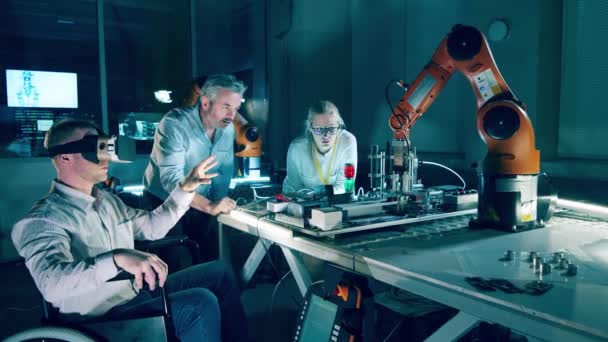 机器人实验室有一个坐在轮椅上的工程师和他的同事4K — 图库视频影像