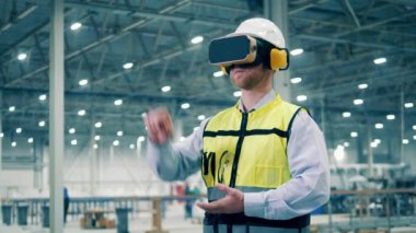 Male engineer is using VR-glasses while working in the factory. 4K