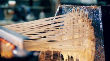 Yapıştırıcıyla kaplı fiberglas iplikler bir araya geliyor. 4K