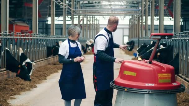 Two Farmworkers Operating Automated Feed Pusher — Stock video
