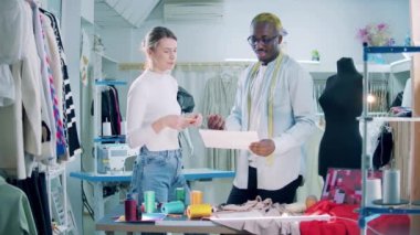 Two dressmakers are discussing work in the studio. 4K