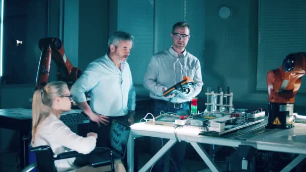 Group Engineers Observing Robotic Arm Talking — Video Stock
