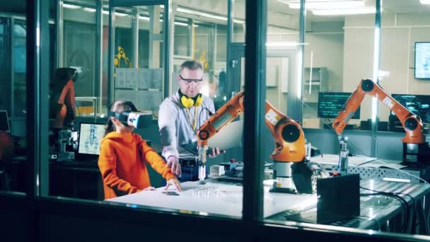 Engineer Helping Girl Glasses Operate Robotic Arm — Vídeo de Stock