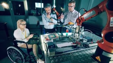 Bir grup mühendis laboratuvarda robotları tartışıyorlar. 4K