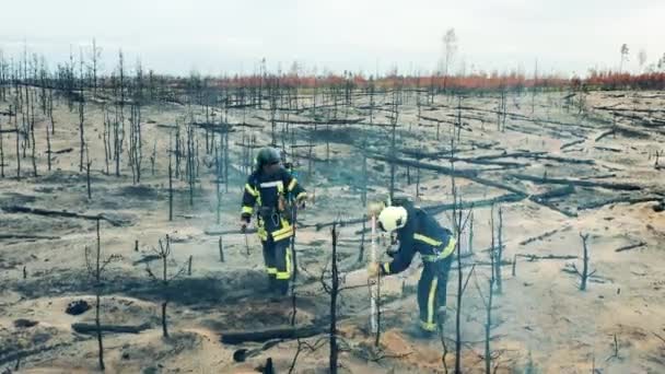 Burnt Out Forest Ground Getting Smothered Two Firefighters — Vídeo de stock