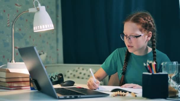 여학생은 노트북을 사용하여 집에서 온라인으로 공부하고 있습니다 — 비디오
