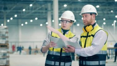Two industrial engineers are talking about a factory project. 4K