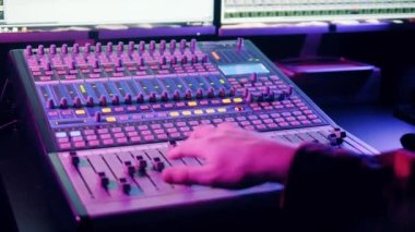 Mixing console is getting operated by a sound producer. 4K