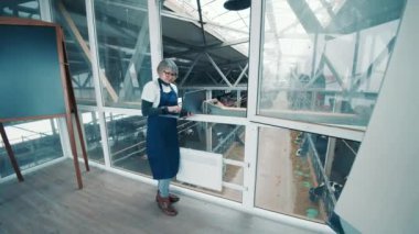 Female cattle farmer is using a laptop in the office space. 4K