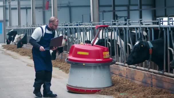 Ganadero Controla Una Máquina Que Empuja Heno Las Vacas — Vídeo de stock