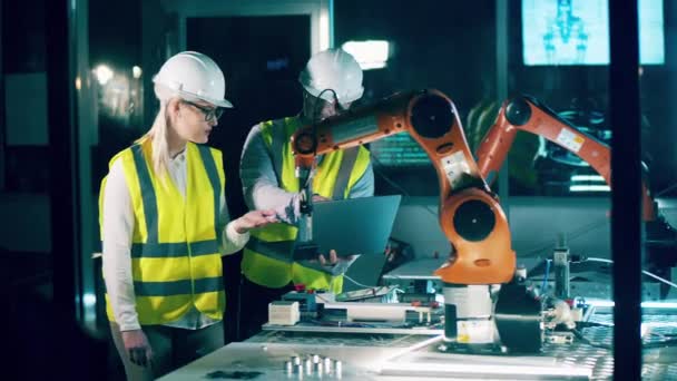 两名穿着工作服的工程师正在研究机器人 — 图库视频影像