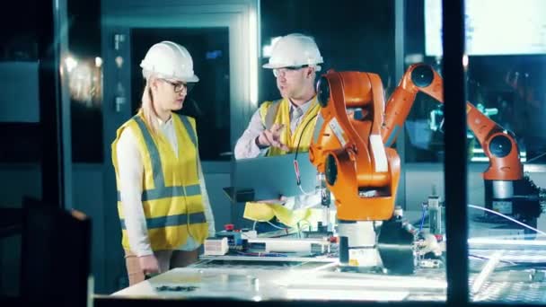 Two Engineers Workwear Operating Robots Lab — стоковое видео