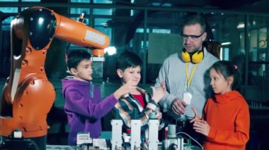 Bir grup çocuk öğretmenleriyle birlikte robotlar üzerinde çalışıyor. 4K