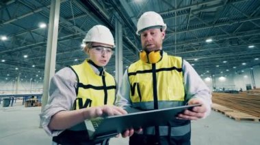 Factory coworkers are discussing a project. 4K