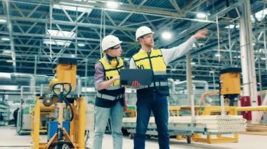 Engineering coworkers are discussing premises of the factory. 4K