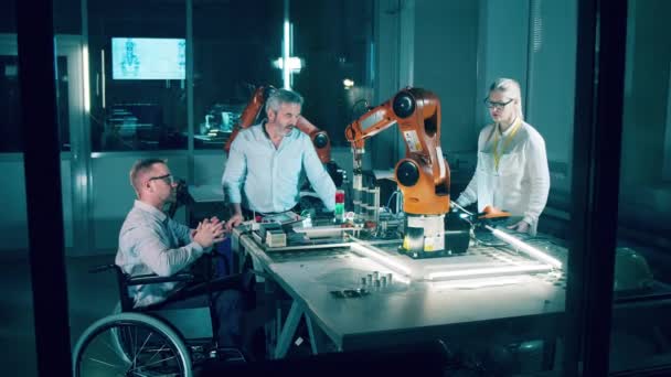残疾专家和他的同事正在研究一个机器人 — 图库视频影像