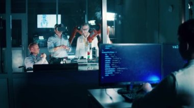 Programcı, içinde mühendislerin olduğu bir robot laboratuvarını izliyor. 4K