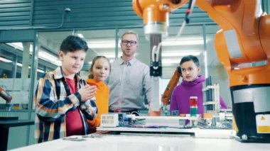 Çocuklar ve bir robot uzmanı robotları gözlemliyor. 4K