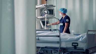 Kadın doktor hasta odasında bir bilgisayar sistemini yönetiyor. 4K