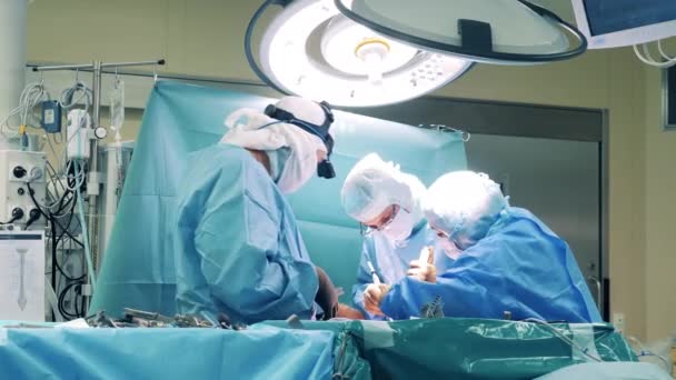 手術はカーテンの後ろの外科医のグループによって行われています — ストック動画