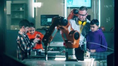 Erkek eğitmen, çocuklara robotları tanıtıyor. 4K