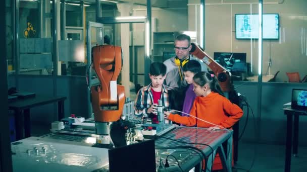 Kinderen Observeren Robotonderdelen Met Hun Instructeur Naast Zich — Stockvideo