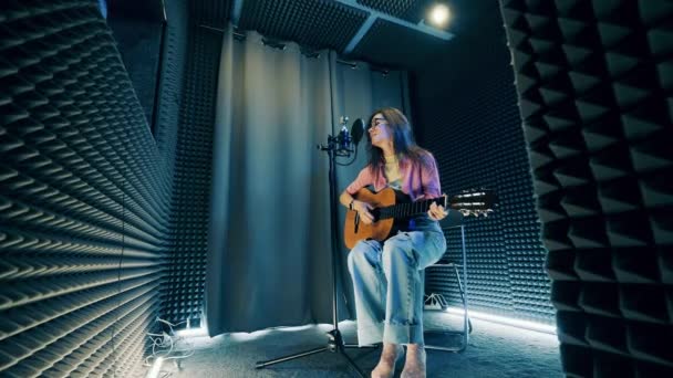 Νεαρή Γυναίκα Παίζει Κιθάρα Και Τραγουδάει Στο Στούντιο — Αρχείο Βίντεο