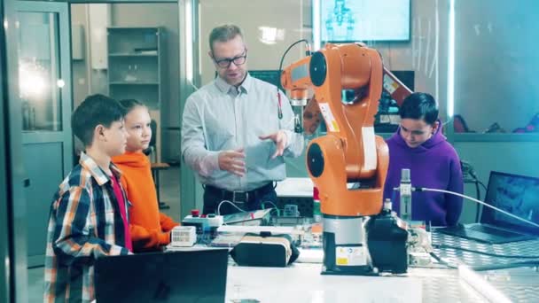 Mannelijke Instructeur Legt Robots Uit Aan Kinderen — Stockvideo